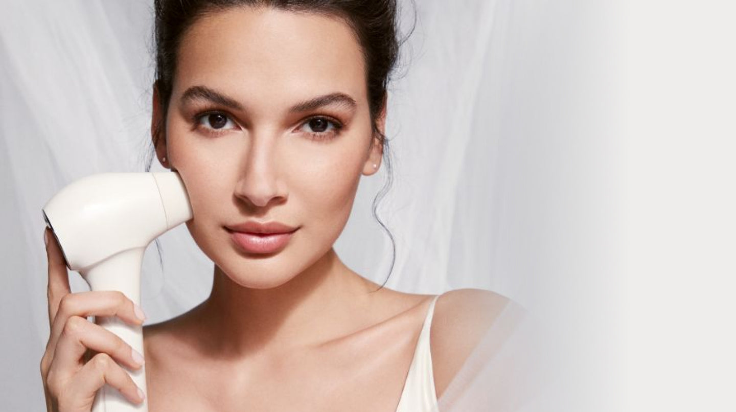 Close up of woman holding a skincare device to her cheek