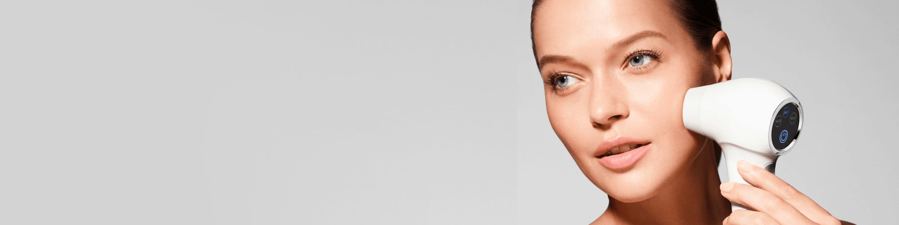Close up of woman's face holding a skincare device to her cheek