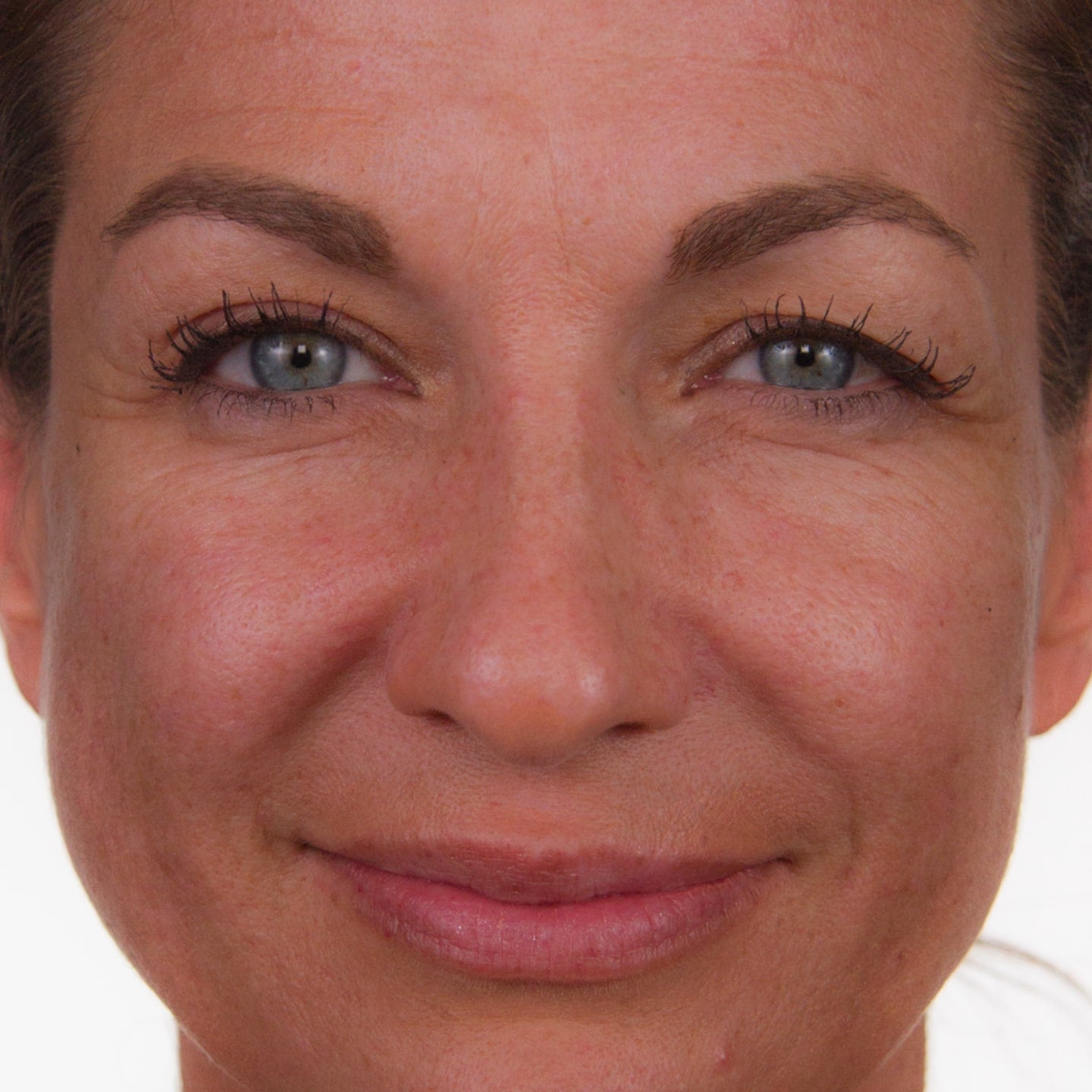 Close up photo of a woman's face as she softly smiles