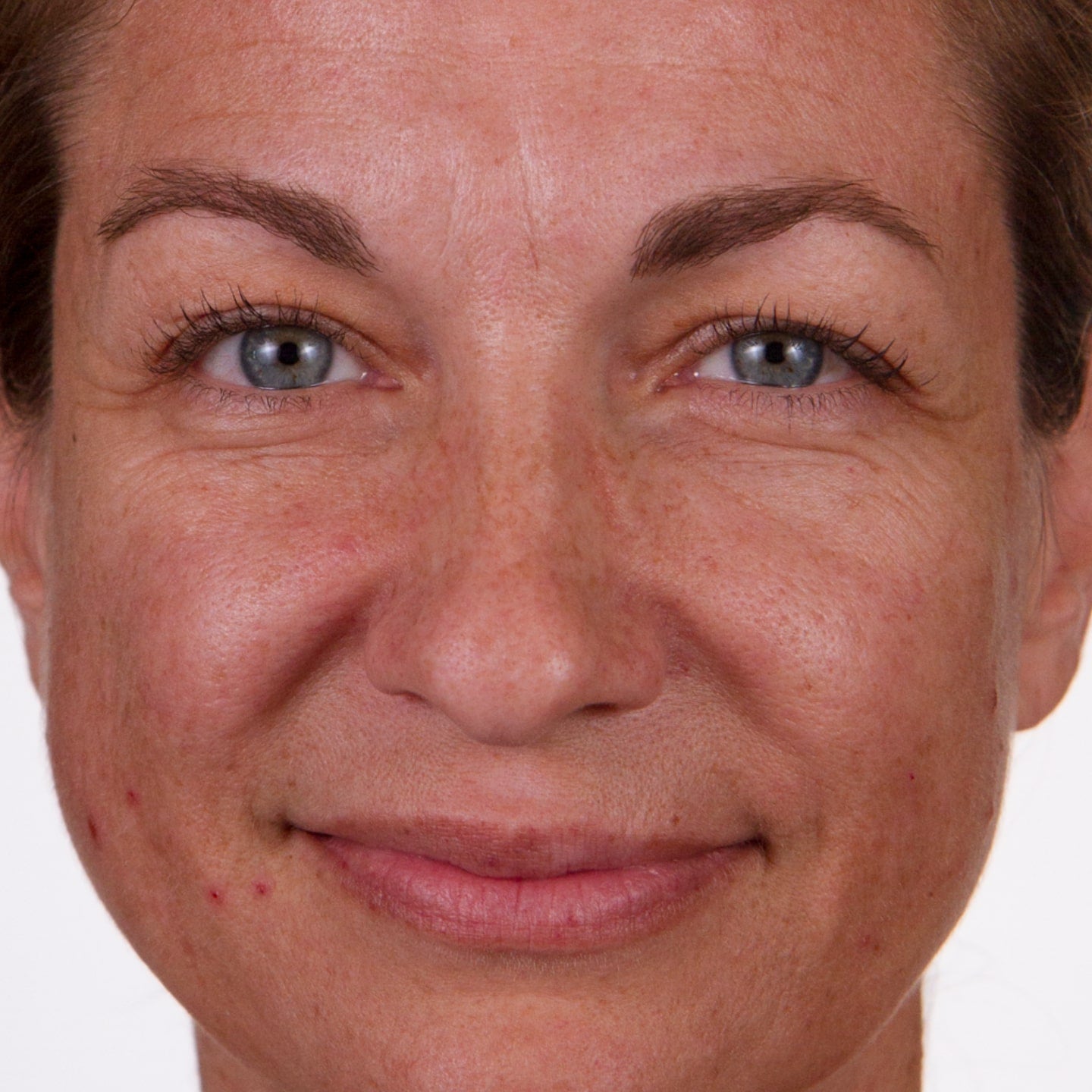 Close up photo of a woman's face as she softly smiles