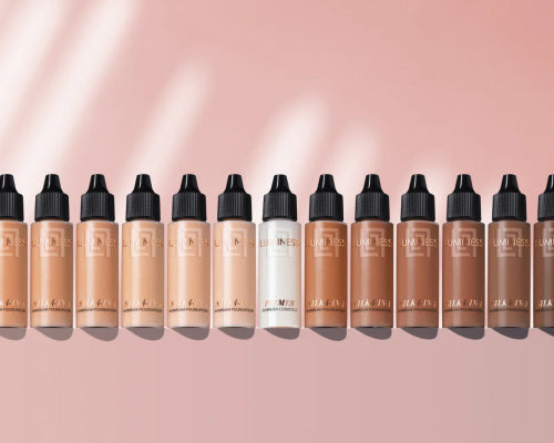 Product photo showcasing multiple bottles of foundation lined up from light shades to darker shades