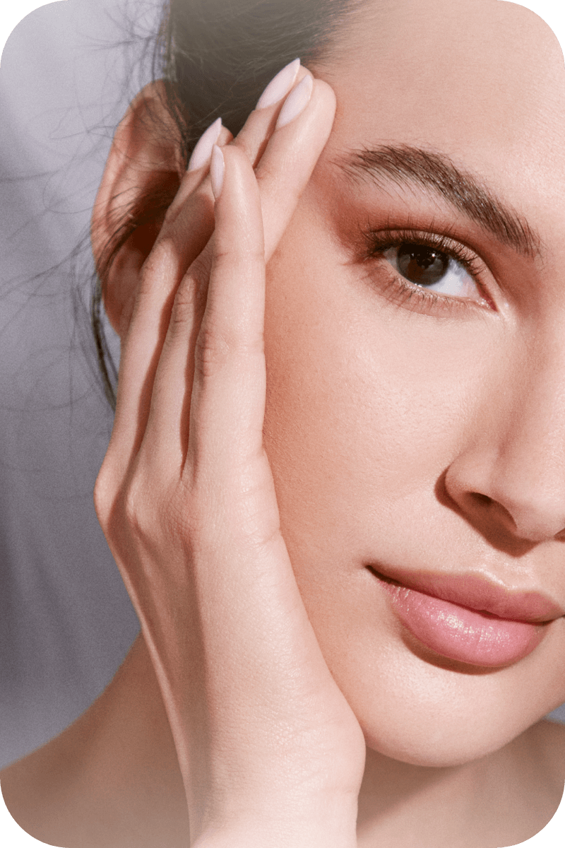 Close up on woman's face as she poses with her hand against the side of her face